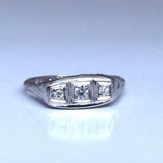 a three stone diamond ring sitting on top of a table