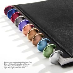 a binder with six different colored glass knobs on the front and back of it