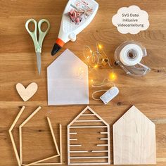 some crafting supplies are laid out on a wooden table with scissors, tape and glue