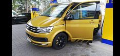 a yellow van parked at a gas station