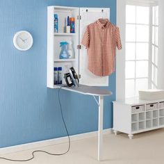 a white ironing board sitting next to a blue wall