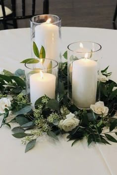 some candles are sitting on a table with flowers