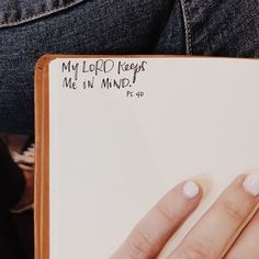 a person's hand holding a notepad with writing on it that says, my lord keeps me in mind