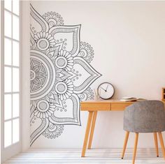 a room with a desk and chair next to a wall decorated with an intricate design