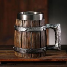 a wooden barrel sitting on top of a table next to a metal handle and ring