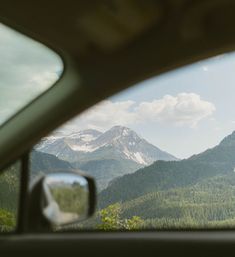 the view from inside a car looking at mountains