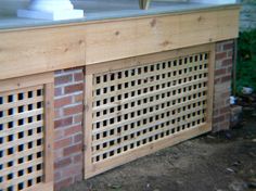 a close up of a grill made out of wood and bricks with holes in it