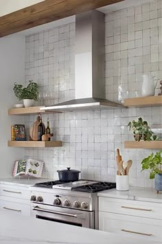 a stove top oven sitting inside of a kitchen next to wooden shelves and white cabinets