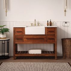 a bathroom with a sink, mirror and rug