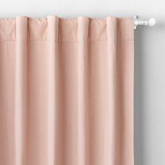 a pink curtain hanging on the side of a window