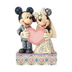 a mickey and minnie mouse figurine holding a heart