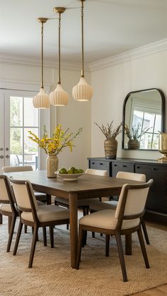 a dining room table surrounded by chairs and vases