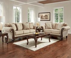 a living room filled with furniture on top of a hard wood floor covered in lots of windows