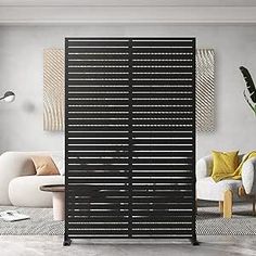 a living room with white furniture and black shutters