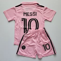 a pink soccer jersey and shorts with the number 10 printed on it, sitting on a grey surface