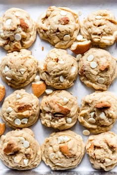 baked cookies with white chocolate chips and almonds on a baking sheet, ready to be eaten