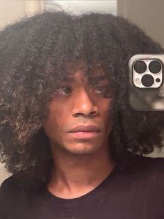 a man with curly hair is taking a selfie