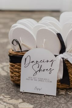 a basket filled with white flip flops sitting on top of a carpeted floor