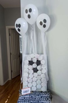 some white balloons are hanging on the wall near a bag with black dots and stars