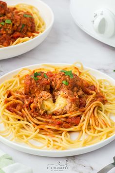 two plates of spaghetti with meatballs and sauce