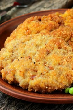 two fried chicken patties on a plate with peas