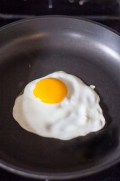 an egg frying in a pan on the stove