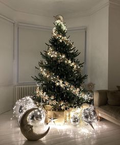 a decorated christmas tree in a living room with presents under it and lights on the floor