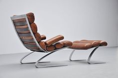 a reclining chair with a footstool made out of leather and metal legs