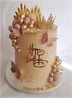 a birthday cake decorated with gold and pink decorations