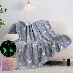 a blanket with green stars and moon on it next to a couch in a living room