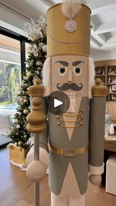 an inflatable nutcracker with a beard and mustache is standing in front of a christmas tree