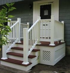 a white porch with steps leading up to the front door