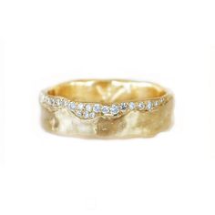 a gold wedding band with diamonds on it