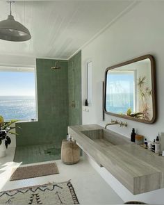 a bathroom with a sink, mirror and bathtub in front of a large window