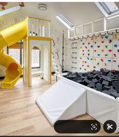 a room with a slide and climbing wall