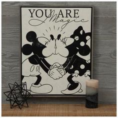 a mickey mouse poster with the words you are magic on it next to a candle