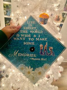 someone is holding up a graduation cap that says life is short, the world is wide & i want to make some memories