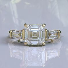 an emerald cut diamond ring with three baguetts