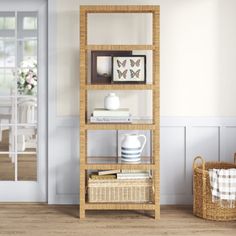 a shelf with books and pictures on it next to a basket in front of a door