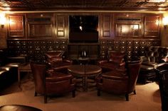 a living room with leather chairs and a television