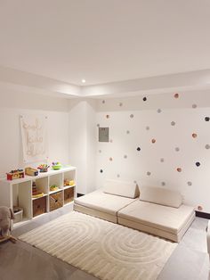 a living room with white furniture and polka dot wallpaper on the walls in it