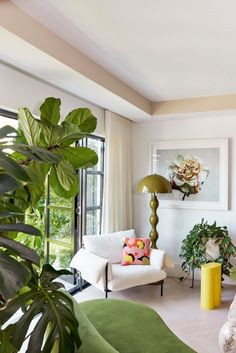 a living room filled with furniture and lots of plants