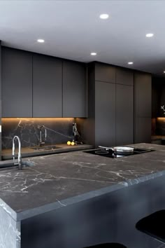 a kitchen with marble counter tops and black cabinets