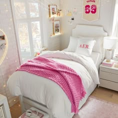 a white bed with pink blankets and pillows in a room decorated for valentine's day