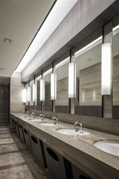 a public restroom with double sinks and mirrors