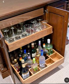 an open cabinet filled with bottles and glasses