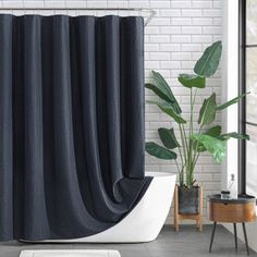 a black shower curtain in a bathroom with white brick walls and grey tile flooring