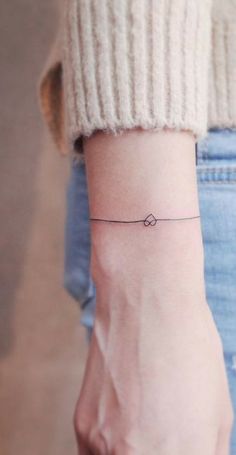 a woman's wrist with a small tattoo on it