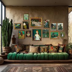 a living room filled with lots of pictures on the wall and green couches covered in pillows