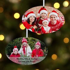 two christmas ornament hanging from a tree with lights in the background and a brick wall behind it